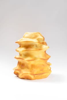 Isokated Sakotis ,sekacz, baumkuchen, traditional spit cake in lithuanian, polish, german, belarusian cuisine made of butter,eggs,flour,sugar, cooked over open fire on white background Vertical plane