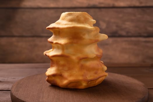 Sakotis ,sekacz, baumkuchen on wooden table, traditional spit cake of lithuanian, polish, german, belarusian cuisine made of butter,eggs,flour,sugar, cooked over open fire. Horizontal, copyspace