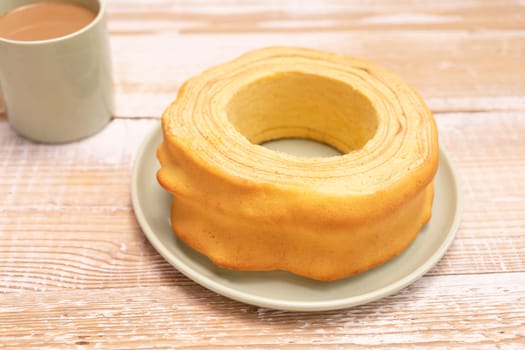 Closeup Baumkuchen, sakotis ,sekacz on wooden rustic table with cup of coffee, traditional spit cake of lithuanian, polish, german, belarusian cuisine made of butter,eggs,flour,sugar. Horizontal