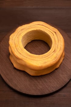 Top view of baumkuchen, sakotis ,sekacz on wooden table, traditional spit cake of lithuanian, polish, german, belarusian cuisine made of butter,eggs,flour,sugar cooked over open fire.Vertical,flatly