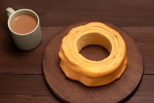 Top view of baumkuchen, sakotis ,sekacz on brown wooden table, delicious homemade traditional spit cake with a cup of coffee. Horizontal plane, flatly.