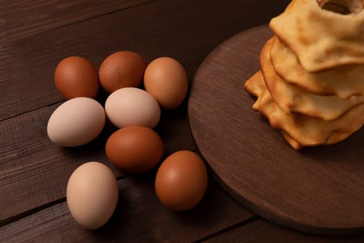 Top view Eggs near baumkuchen, sakotis ,sekacz on wooden table, sweet traditional spit cake of lithuanian, polish, german, belarusian cuisine made of butter, eggs, flour, sugar. Horizontal Plane.