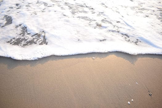 White wave of blue sea on sandy beach. Natural background.