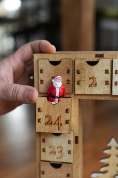 Hand opens wooden advent calendar