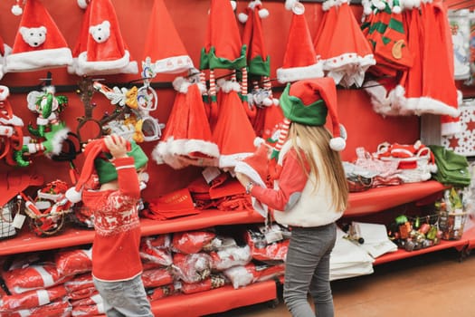 Children choose a santa claus hat in the store