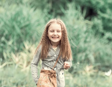 cute little girl is walking in the summer wood