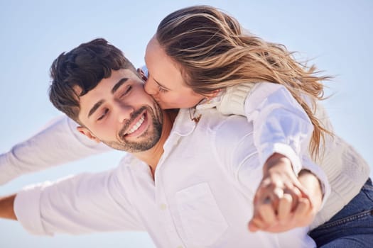 Piggyback, relax or couple love to kiss on holiday vacation or romantic honeymoon in a marriage commitment. Travel, trust or woman bonding, kissing or hugging a happy partner in fun summer romance.