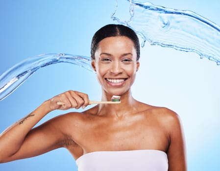 Dental, water and black woman with toothbrush, clean breath and health for teeth and gums, hygiene portrait against blue studio background. Oral health, toothpaste and beauty with water splash