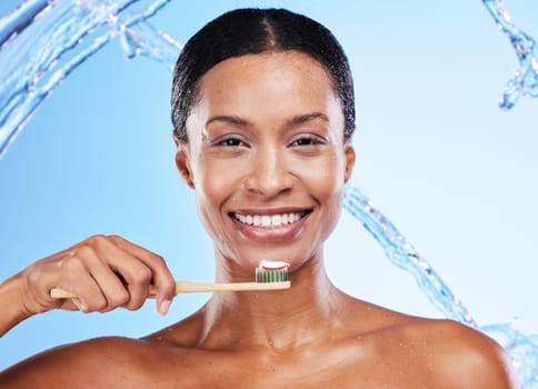 Toothpaste product, toothbrush and black woman, dental cleaning and water splash in blue studio background. White teeth, healthy mouth and hygiene with beauty advertising, oral smile and mouth health.