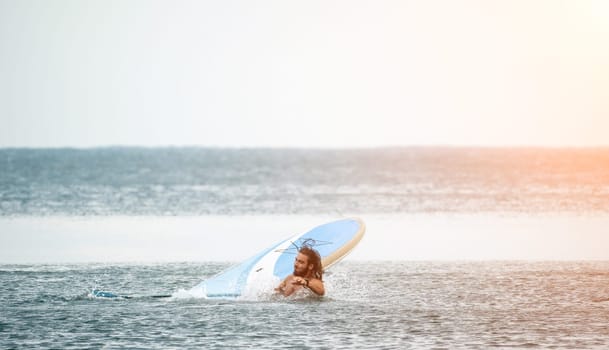 Sea woman and man on sup. Silhouette of happy young woman and man, surfing on SUP board, confident paddling through water surface. Idyllic sunset. Active lifestyle at sea or river
