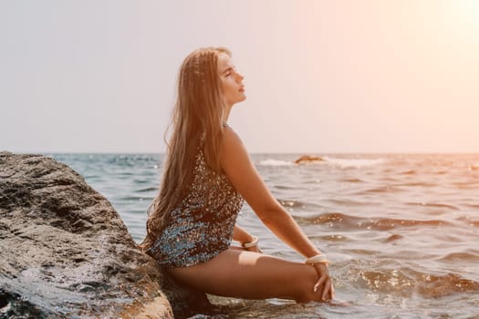 Woman travel sea. Young Happy woman in a long red dress posing on a beach near the sea on background of volcanic rocks, like in Iceland, sharing travel adventure journey