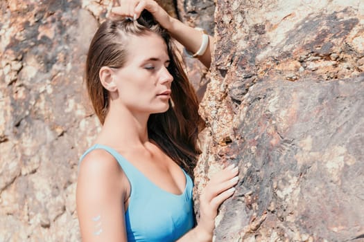 Woman travel sea. Young Happy woman in a long red dress posing on a beach near the sea on background of volcanic rocks, like in Iceland, sharing travel adventure journey