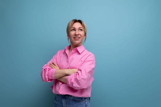 young confident smart european blond office worker woman wearing pink shirt and jeans over isolated studio background with copy space.