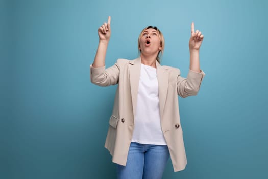 close-up of positive cheerful blonde business woman demonstrating having an idea with hands on blue background with copy space.