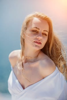 Portrait of a blond woman at the sea, a woman makes photos for memory from a trip to the sea to show to friends