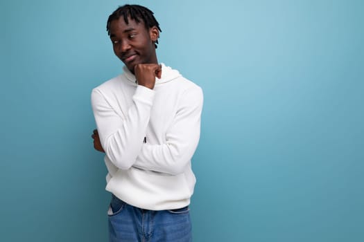 handsome optimistic man with dreadlocks on a blue background.