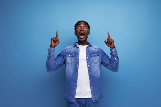 charismatic dude african man with curly hair in a denim jacket on a blue background.