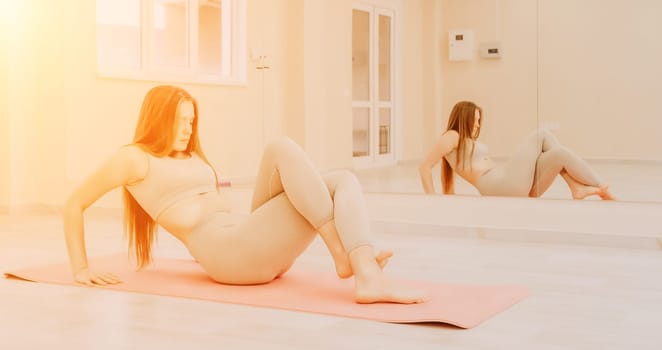 Group of young womans fitness instructor in Sportswear Leggings and Tops, stretching in the gym before pilates, on a yoga mat near the large window on a sunny day, female fitness yoga routine concept.