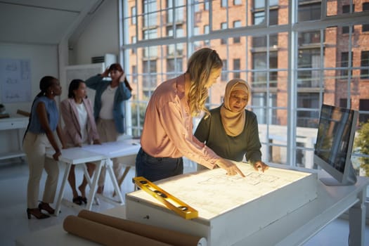 Architecture, blueprint and women meeting, planning and working on design for a construction job on paper. Teamwork, collaboration and employees in communication about strategy for infrastructure.