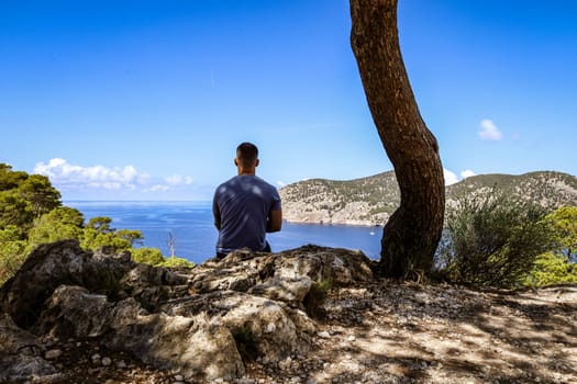 Young man enjoying the view of mountains and Mediterranean sea. High quality photo