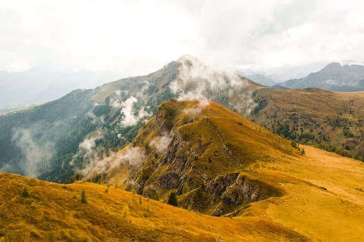 Famous Giau Pass, where the slopes are bedecked with a majestic mountain range, draped in a misty veil of clouds.