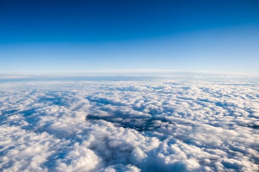 View from the plane to the clouds and blue sky.