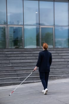 Blind businesswoman walking with tactile cane to business center