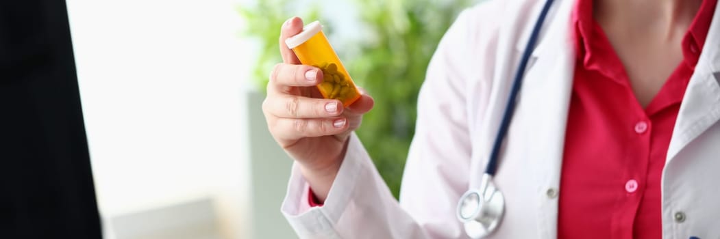 Hands of female doctor hold jar of pills closeup. Medicines and treatment of diseases