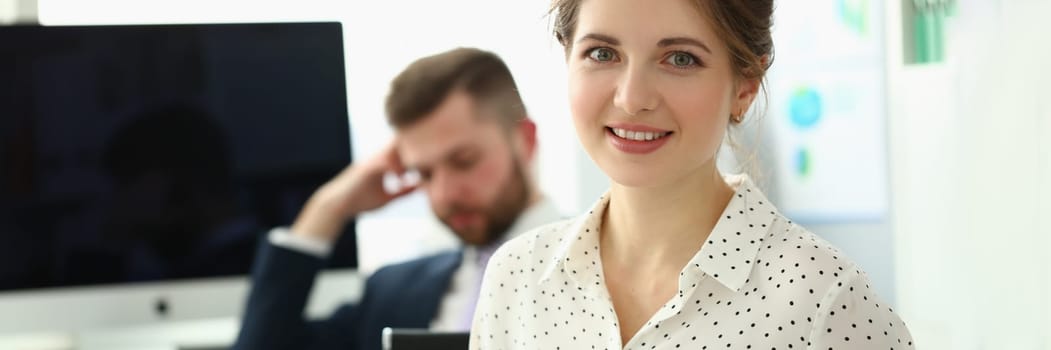 Business lady with positive look and cheerful smile poses for camera. Work in modern office concept