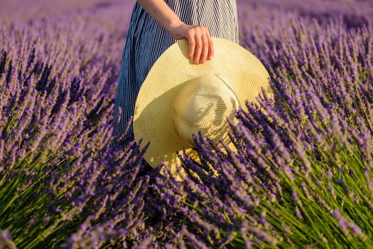 A girl delicately cradles a straw hat in her hands, surrounded by the soothing hues of a lavender field, creating a scene that emanates tranquility and natural beauty.