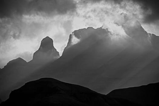Monochrome image of a stormy sunset at Cathedral Peak in the Drakensberg Mountains. KwaZulu-Natal Province, South Africa