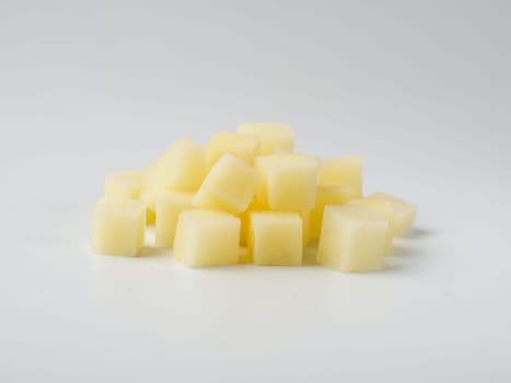 Heap of diced raw potatoes isolated on white background. Pile uncooked potatoes cube.