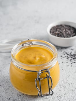 Creamy Cheddar sauce with chia seeds on gray background.Ideas and recipe for healthy diet or vegan food.Homemade Chia Cheeze Sauce for snacks,tacos,nachos,dipping,mac-n-cheese,base for pizza.Copyspace