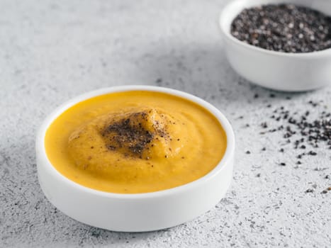 Creamy Cheddar sauce with chia seeds on gray background.Ideas and recipe for healthy diet or vegan food.Homemade Chia Cheeze Sauce for snacks,tacos,nachos,dipping,mac-n-cheese,base for pizza.Copyspace