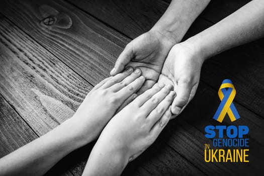 childrens hands holding each other with words stop genocide in ukraine. black and white. concept needs help and support, truth will win