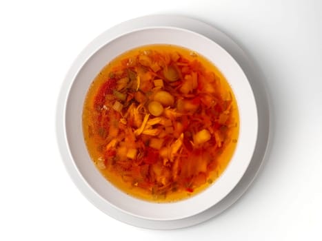 Bowl with chicken, beetroot and other vegetables soup. Perfect bright broth in italian minestrone style, isolated on white. Top view or flat lay.