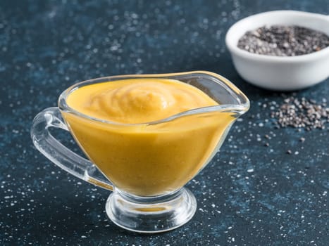 Creamy Cheddar sauce with chia seeds on dark background.Ideas and recipe for healthy diet or vegan food.Homemade Chia Cheeze Sauce for snacks,tacos,nachos,dipping,mac-n-cheese,base for pizza.Copyspace