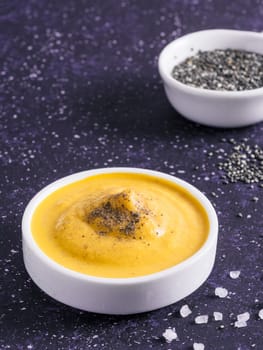Creamy Cheddar sauce with chia seeds on dark background.Ideas and recipe for healthy diet or vegan food.Homemade Chia Cheeze Sauce for snacks,tacos,nachos,dipping,mac-n-cheese,base for pizza.Copyspace