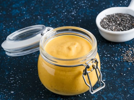 Creamy Cheddar sauce with chia seeds on dark background.Ideas and recipe for healthy diet or vegan food.Homemade Chia Cheeze Sauce for snacks,tacos,nachos,dipping,mac-n-cheese,base for pizza.Copyspace