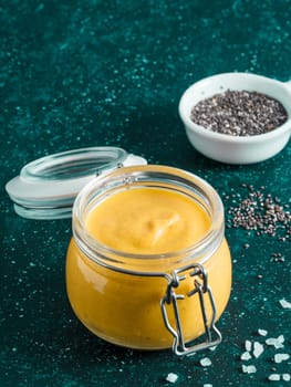 Creamy Cheddar sauce with chia seeds on dark background.Ideas and recipe for healthy diet or vegan food.Homemade Chia Cheeze Sauce for snacks,tacos,nachos,dipping,mac-n-cheese,base for pizza.Copyspace