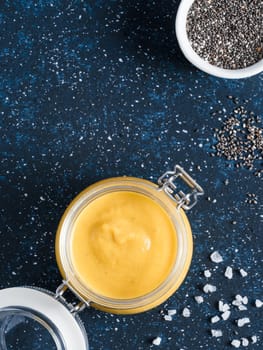 Creamy Cheddar sauce with chia seeds on dark background.Ideas and recipe for healthy diet or vegan food.Homemade Chia Cheeze Sauce for snacks,tacos,nachos,dipping,mac-n-cheese,base for pizza.Copyspace