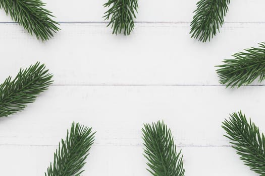 Top view of fir tree branches on white table background for nature and Christmas decoration concept