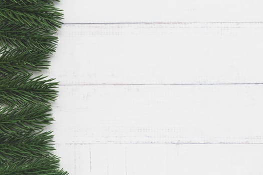 Top view of fir tree branches on white table background for nature and Christmas decoration concept