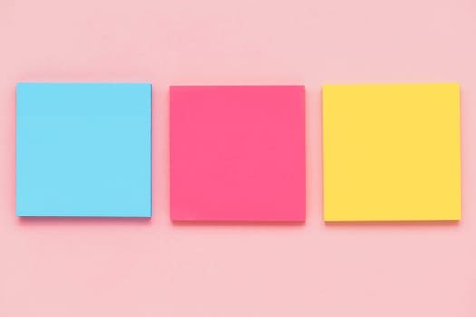 Top view of sticky paper notes on pink background for office and school stationary concept