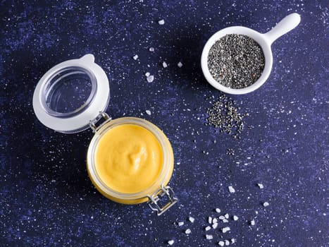Creamy Cheddar sauce with chia seeds on dark background.Ideas and recipe for healthy diet or vegan food.Homemade Chia Cheeze Sauce for snacks,tacos,nachos,dipping,mac-n-cheese,base for pizza.Copyspace
