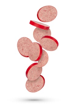Flying sausage. Slices of salami sausage on a white isolated background. Slices of sausage scatter in different directions and fall casting a shadow. To be inserted into a design or project