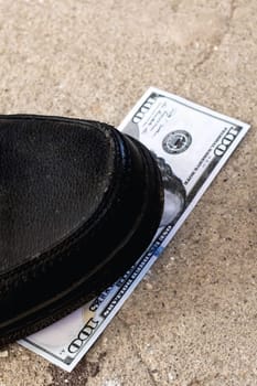 One hundred dollar bill under the shoe close up