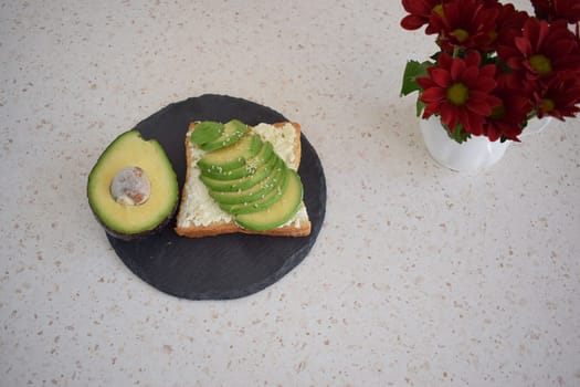 Healthy breakfast toast with avocado, ricotta and herbs.
