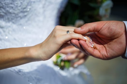 gold wedding rings in the hands of the newlyweds