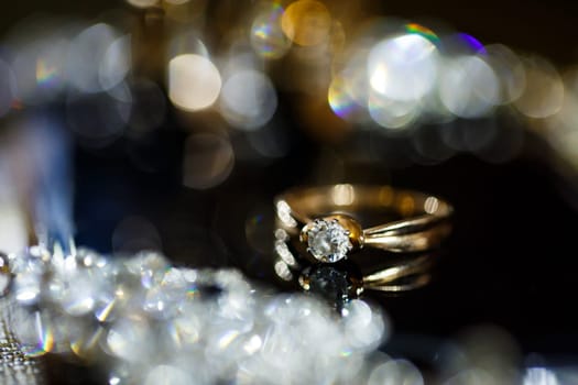 Gold wedding ring on black glass